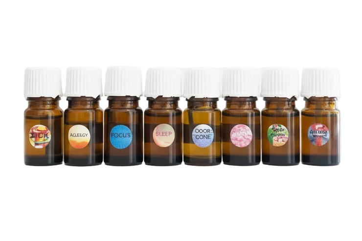 Row of small brown glass bottles with colorful labels on a white background